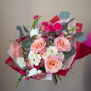 St. Louis Valentine's Day bouquet featuring pink and white flowers wrapped in red and pink tissue paper.